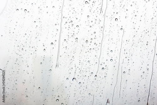 Abstract of water droplets on mirror with city background in raining day