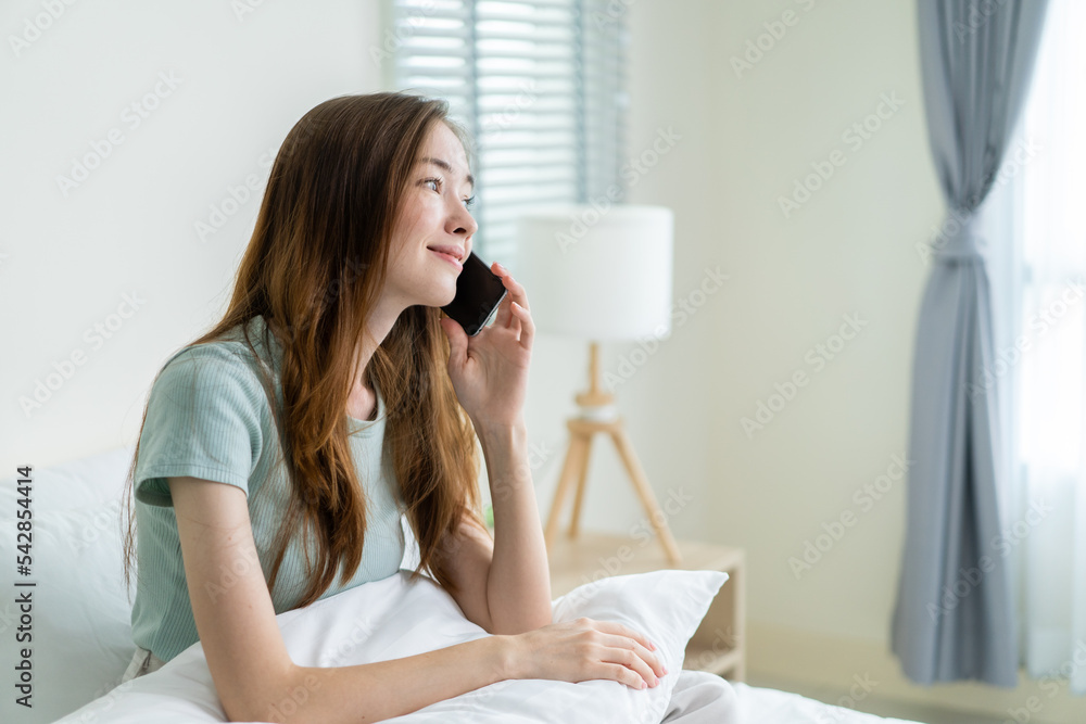 Young Caucasian woman use mobile phone call on bed at home in morning. Young Caucasian woman use mobile phone call on bed at home in morning.