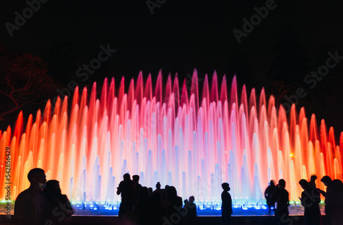 People looking at an impressive and colorful fountain in the Magic water circuit at Reserve park, Lima, Peru photo