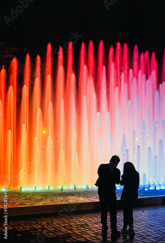 People looking at an impressive and colorful fountain in the Magic water circuit at Reserve park, Lima, Peru