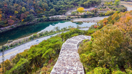 Aerial view of fortress wall and river beside highway on sunny fall day. photo