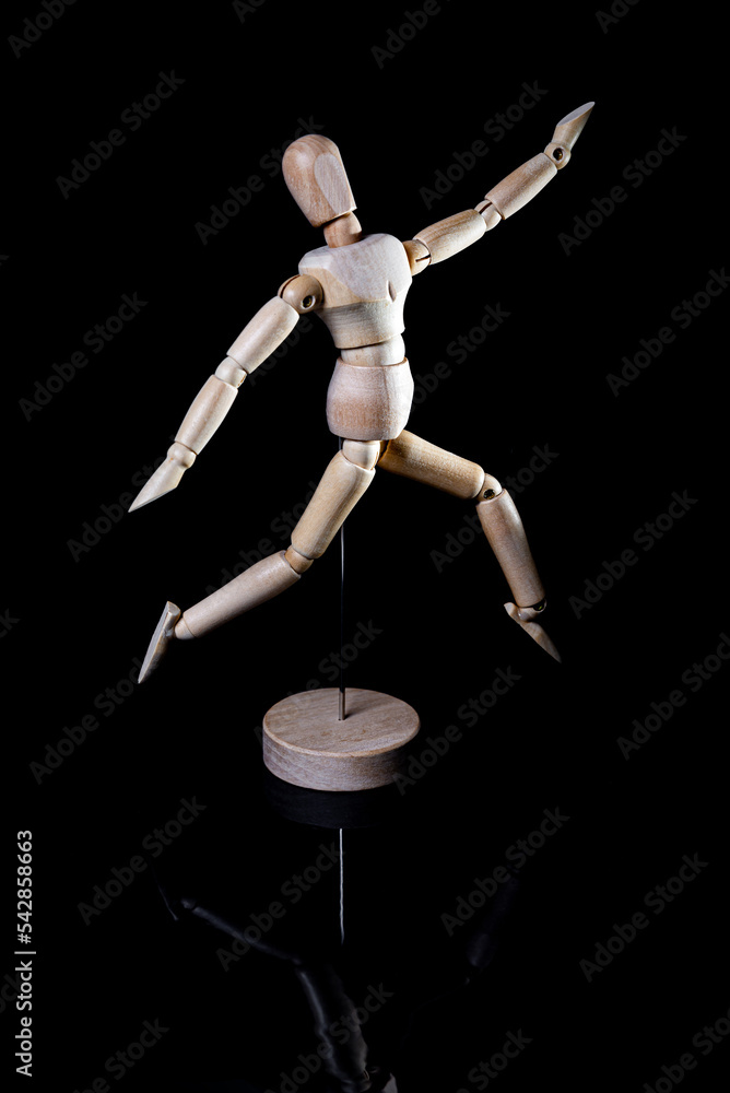 Image of wooden manikin on black background poses different posing Image of wooden manikin on black background poses different posing