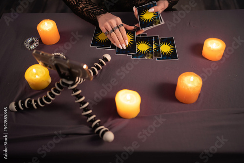 Fortune teller reading fortune lines on screen smartphone, online fortune telling application. Palmistry Psychic readings and clairvoyance concept with Tarot cards photo
