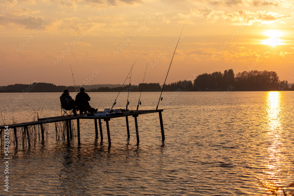 Fishing rods on the lake at sunset.