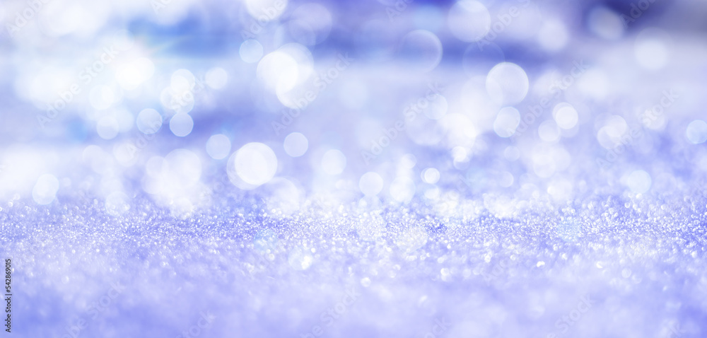 Thin line of focus on snow with Defocused Image Of Illuminated purple Christmas Lights Against Sky During Winter