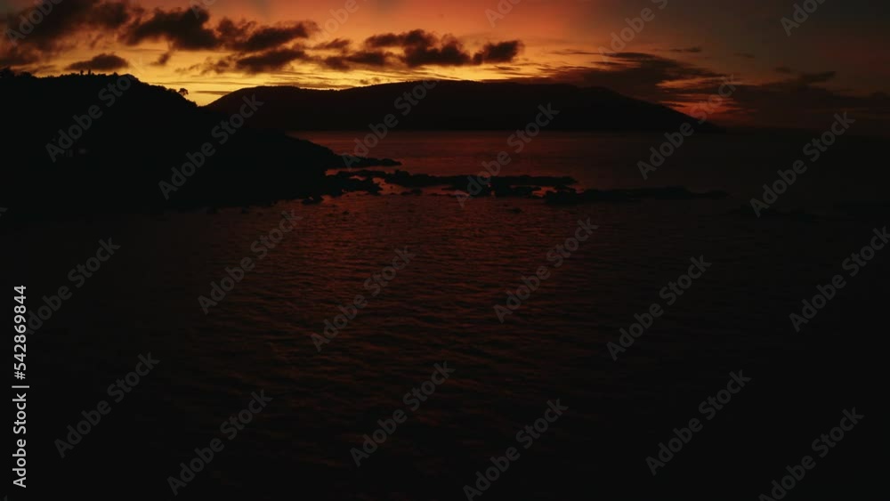 Bright orange sunset sky over tropical islands and ocean in Australia Bright orange sunset sky over tropical islands and ocean in Australia