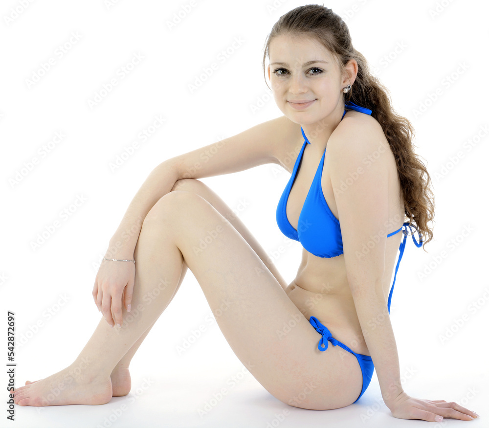 Pretty teenage girl wearing blue bikini in front of white background  isolated in studio Stock Photo