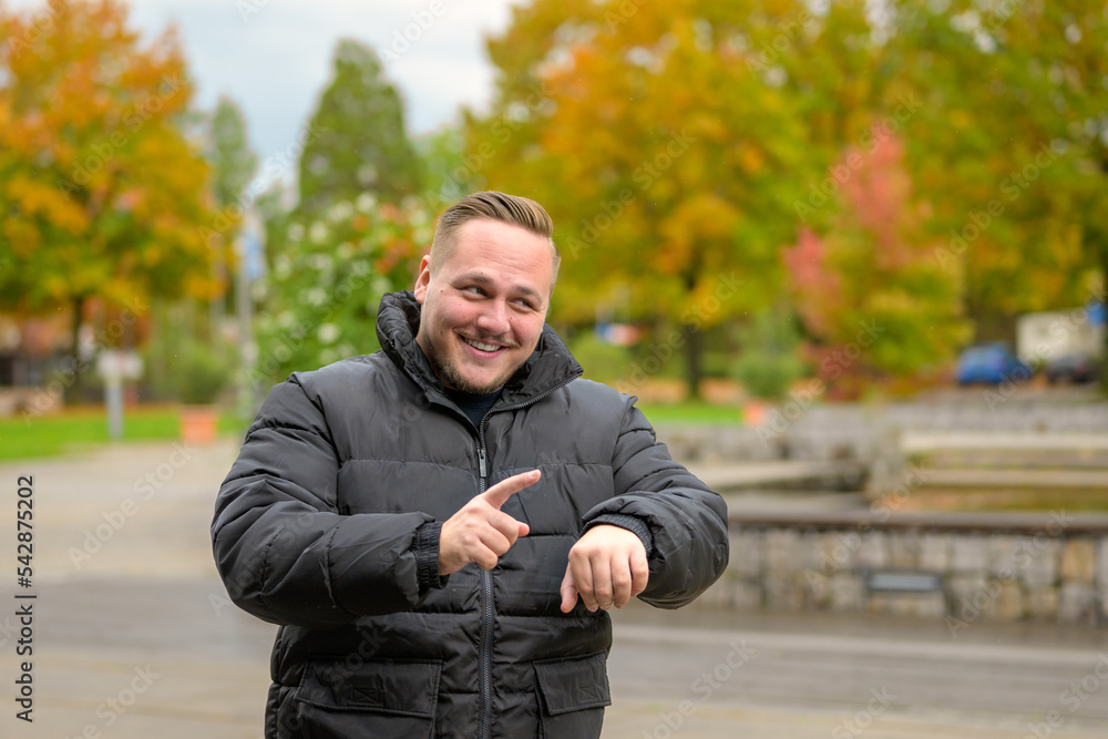 Young man pointing to his wrist Young man pointing to his wrist