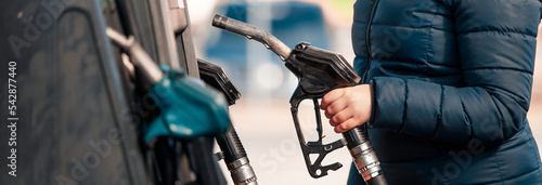 High prices of petrol and diesel fuel ath the petrol station, young woman refueling the car, economic crisis concept photo