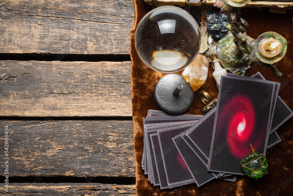 Tarot cards and crystal ball on the old fortune teller desk table