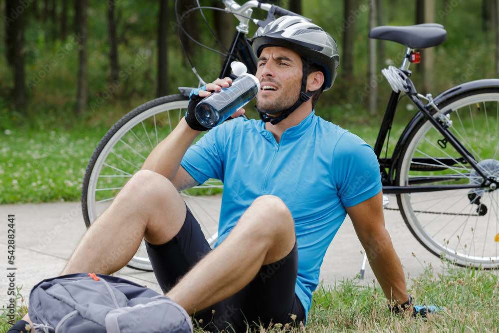 Naklejka premium guy on a bike with a bottle outdoors