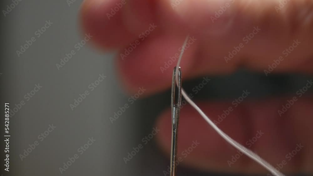 Tailor Hand Inserting Sewing Thread in Needle Hole. Man Preparing Needle with Thread, Getting Ready for Homemade Sewing Activity. Tailor Hand Inserting Sewing Thread in Needle Hole. Man Preparing Needle with Thread, Getting Ready for Homemade Sewing Activity.
