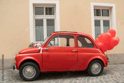 kleines rotes Auto mit roten Luftballons © Anastasiia
