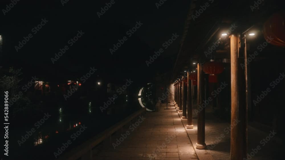 Night time by a river in a classic Chinese building decorated red lanterns. Night time by a river in a classic Chinese building decorated red lanterns.