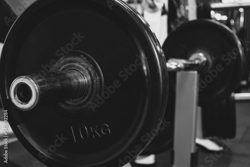 barbell on the trainer for weight training. Bodybuilding equipment. Fitness or bodybuilding concept background. black and white photography