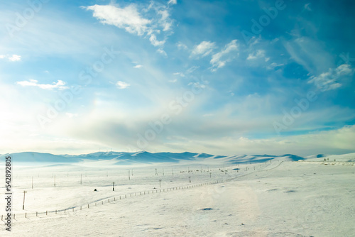 真冬のモンゴルで、鉄道の車窓から見た雪原と青空