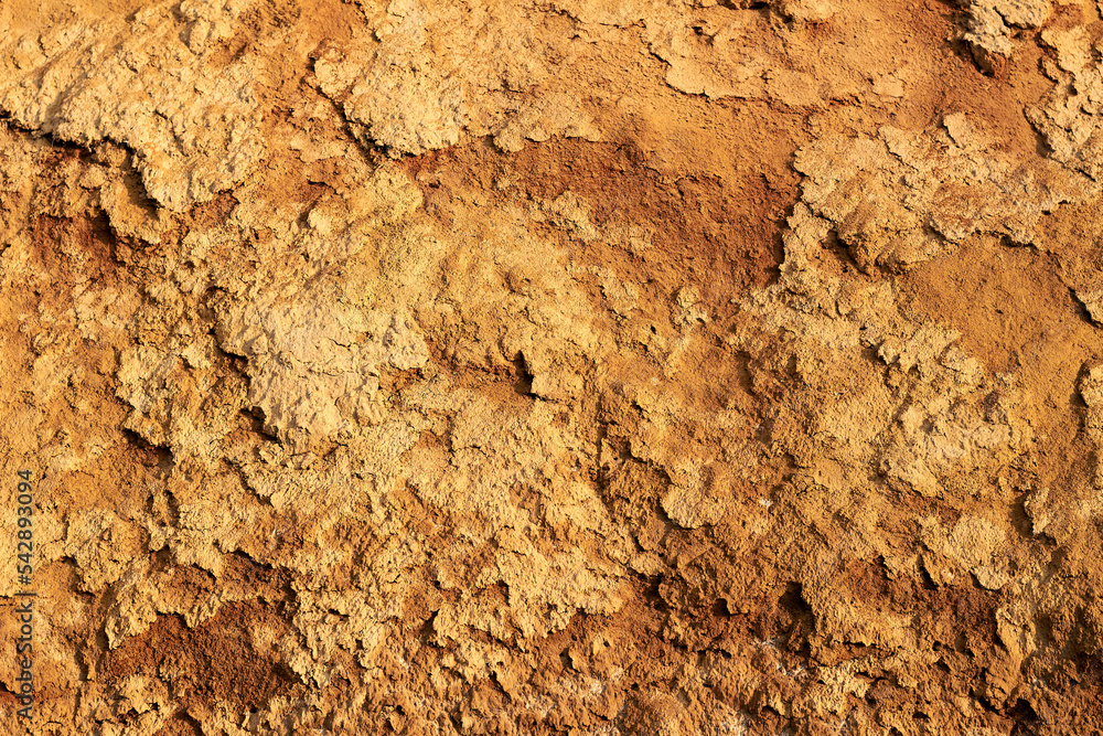 Close up surface of orange brown clay texture of a cliff