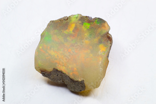 Raw uncut shiny white colorful ethiopian opal crystal stone close up macro isolated on a white surface  photo