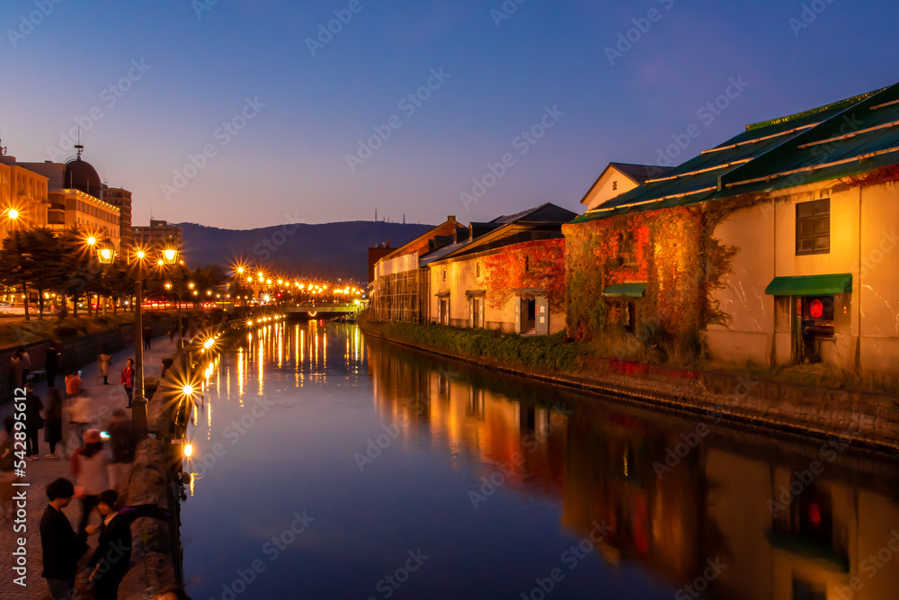 ライトアップされる小樽運河周辺の風景と、夕焼けから夜に変わる空