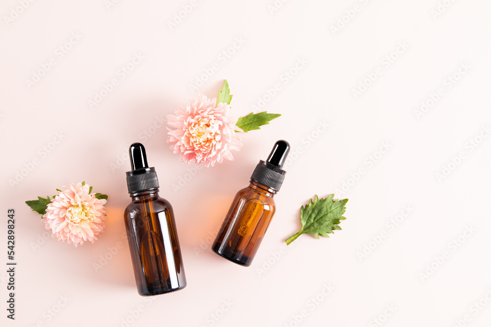 a two glass dropper bottles with a serum for the face or a cosmetic product for the care of anti-aging facial skin. pastel background. top view. a two glass dropper bottles with a serum for the face or a cosmetic product for the care of anti-aging facial skin. pastel background. top view.