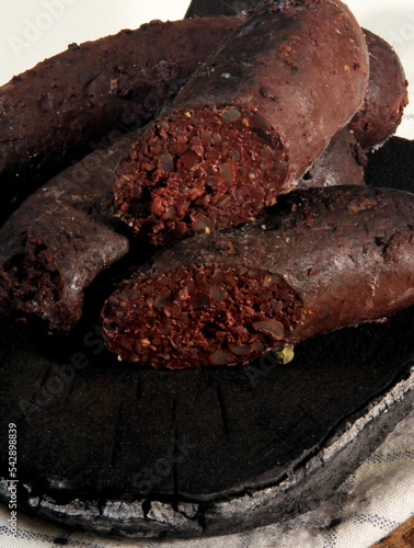 Baked blood sausage. Buckwheat sausage. Blood bloody sausages on wooden cutting board. Homemade black pudding photo