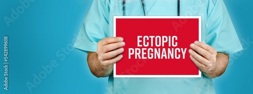 Ectopic pregnancy. Doctor shows red sign with medical word on it. Blue background. photo