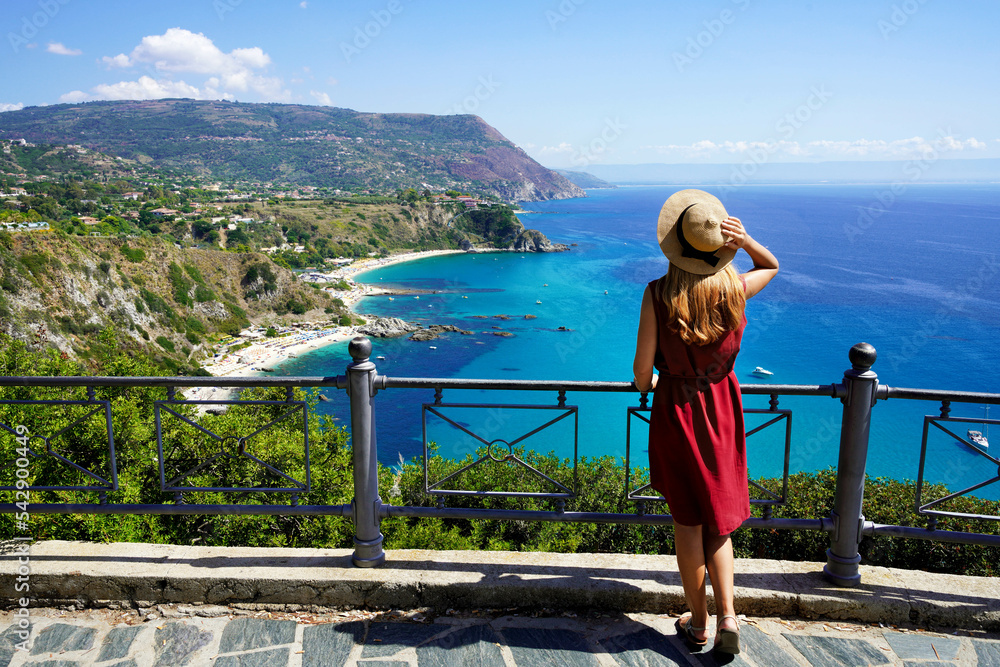 Tourism in Italy. Panoramic view of young woman with hat in Capo Vaticano on the Coast of the Gods, Calabria, Italy.