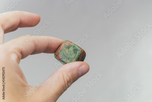 Hand holding unakite healing crystal photo