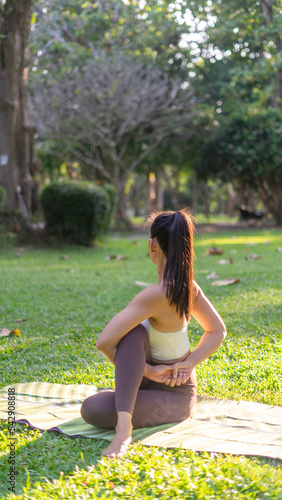 Asian Beauty and healthy woman exercise and doing meditation of yoga on exercise mat in the morning exercise in the park. - fitness, sport, yoka concept. photo