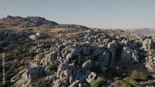 Aerial drone backward moving shot over beautiful rock formations with Karst landscape in the Torcal de Antequera, Malaga, Andalusia, Spain at sunset.  photo