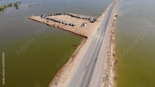 Aerial View Of Makeshift Camp With Tents To House Flood Refugees Beside Only Elevated Road Surrounded By Expansive Flood Waters In Rural Jacobabad, Sindh. photo