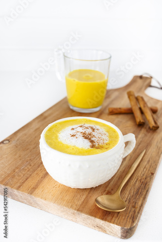 Golden milk with vegetable or cow's milk and with turmeric, cinnamon and other spices. Very aromatic, healthy and tasty drink. photo