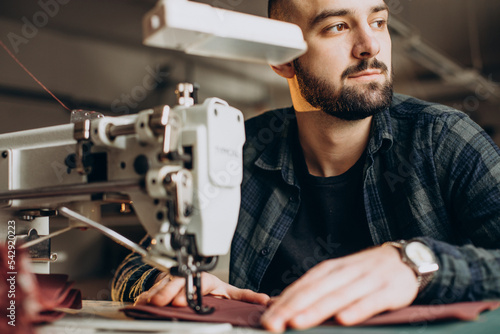 Male designer and leather tailor working at a factory