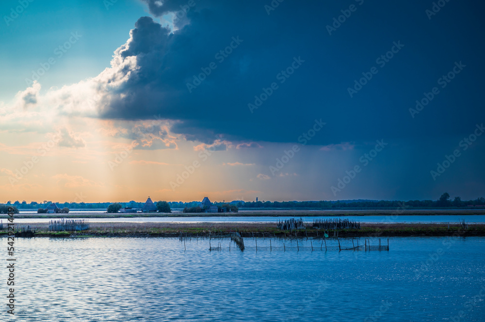 Towards the sunset. Marano lagoon late summer colors. Clouds and sun Towards the sunset. Marano lagoon late summer colors. Clouds and sun