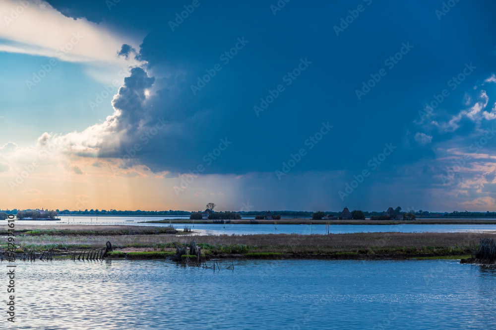 Towards the sunset. Marano lagoon late summer colors. Clouds and sun