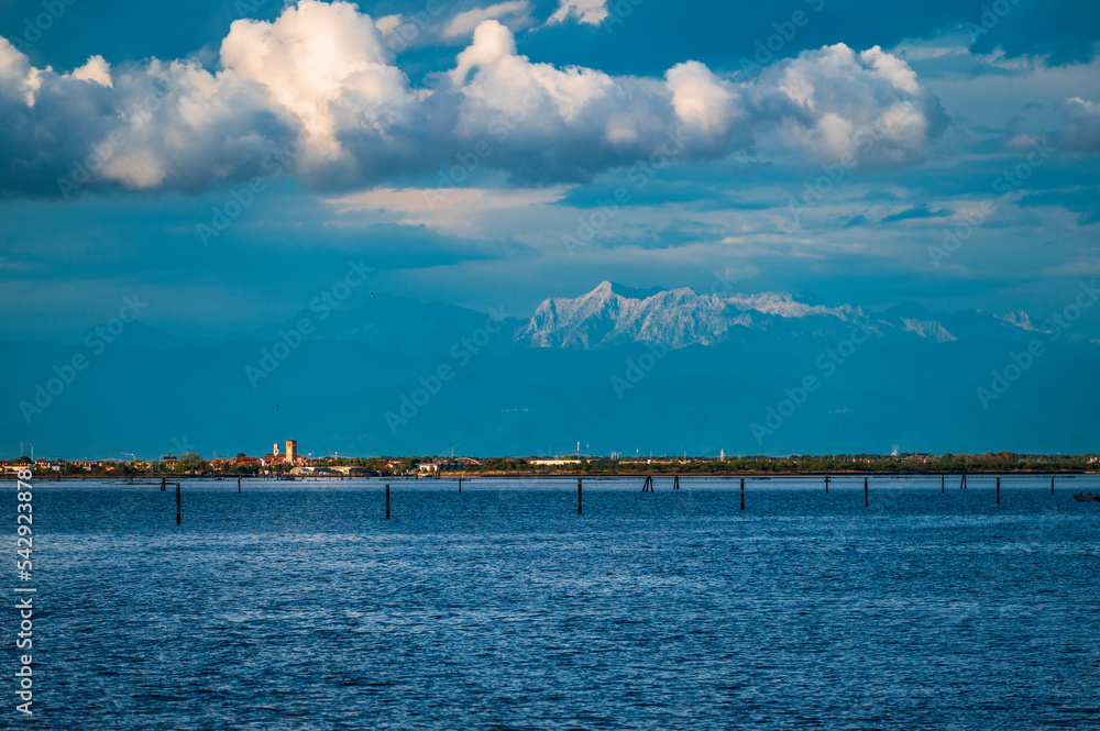 Towards the sunset. Marano lagoon late summer colors. Clouds and sun