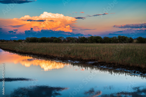 Fototapeta Naklejka Na Ścianę i Meble -  Towards the sunset. Marano lagoon late summer colors. Clouds and sun
