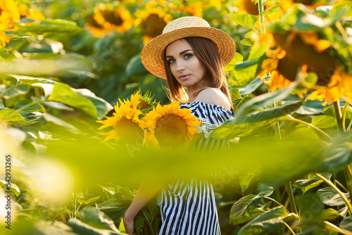 Young woman in hat enjoying summer in sunflower field at sunset © Maksymiv Iurii