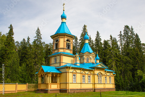 The beautiful Gethsemane Skete of the Valaam Monastery. Blue domes and yellow walls look bright against the backdrop of the forest. photo