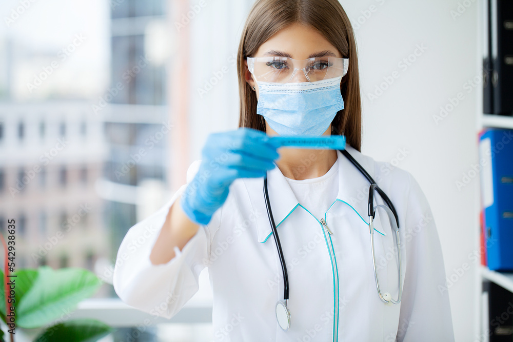 Female doctor in uniform holding a paper signboard lettering covid-19 Female doctor in uniform holding a paper signboard lettering covid-19
