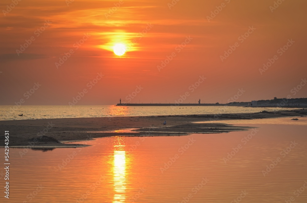 Beautiful sunrise over the sea. Summer morning on the beach in Łeba, Poland. Beautiful sunrise over the sea. Summer morning on the beach in Łeba, Poland.