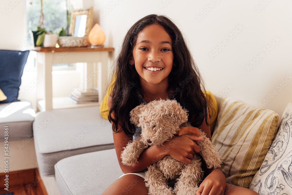 Portrait of a girl with a teddy bear looking at camera while sitting at home. Smiling kid with a toy. Portrait of a girl with a teddy bear looking at camera while sitting at home. Smiling kid with a toy.