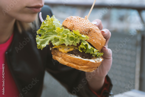 woman eating burger on the street .