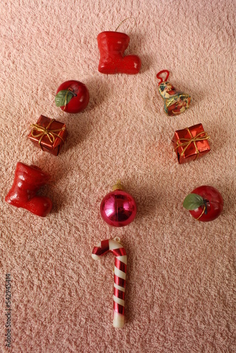 Chucherías, regalos y una bola para la decoración festiva navideña en forma de arbolito para decorar, forman un bonito y original diseño con un fondo de textura rosa naranja photo