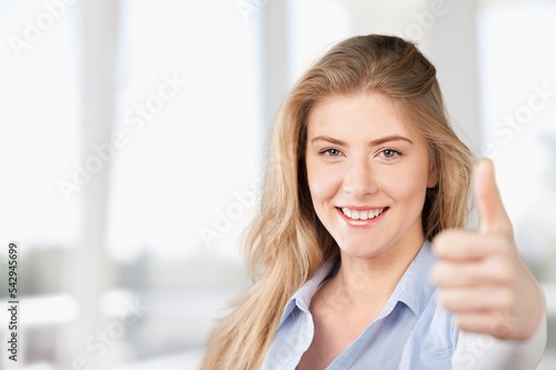 Happy young woman with thumb up posing at home