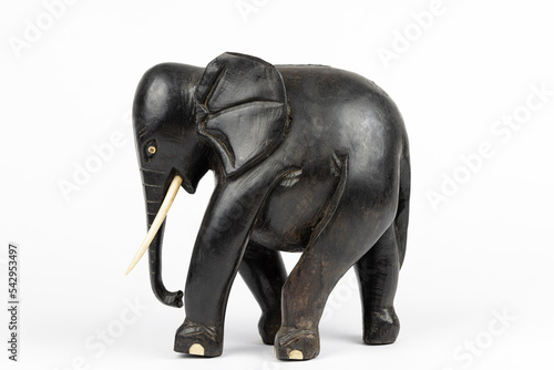 wooden statue of a black african elephant with ivory tusks and toes, isolated on white blackground 