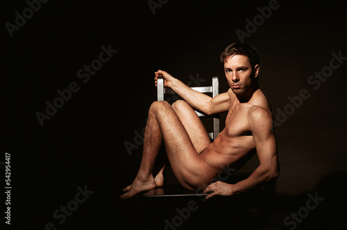 Young attractive guy posing in the studio. Beautiful body.