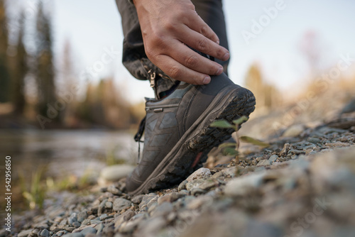 A hiker man puts on sneakers