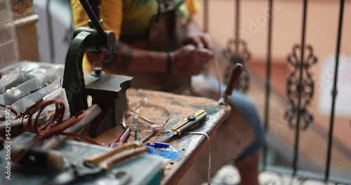 Craftsman making new leather belts at the local market photo