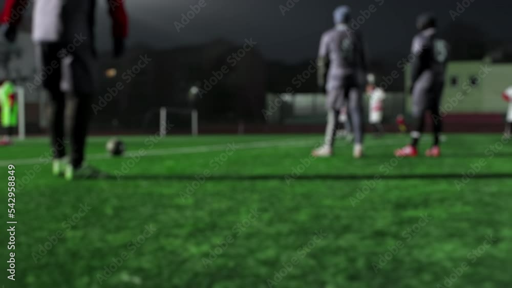 Defensive wall, soccer players are preparing to make direct free-kick near penalty area. Blurred. Football teams are playing friendlie match. Amateur semi-professional game at night in small stadium Defensive wall, soccer players are preparing to make direct free-kick near penalty area. Blurred. Football teams are playing friendlie match. Amateur semi-professional game at night in small stadium